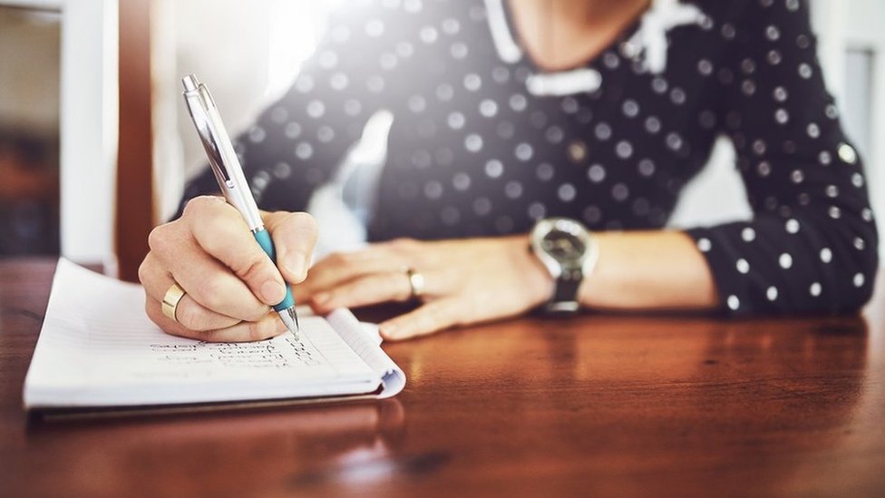 Mujer escribiendo una lista de quehaceres