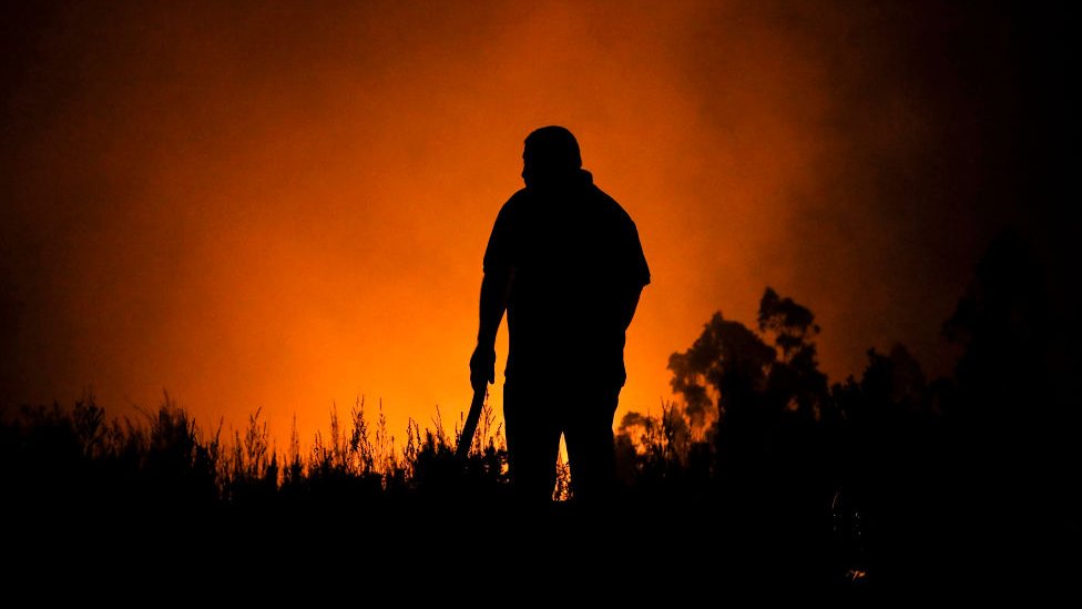 La silueta de un hombre frente a las llamas.