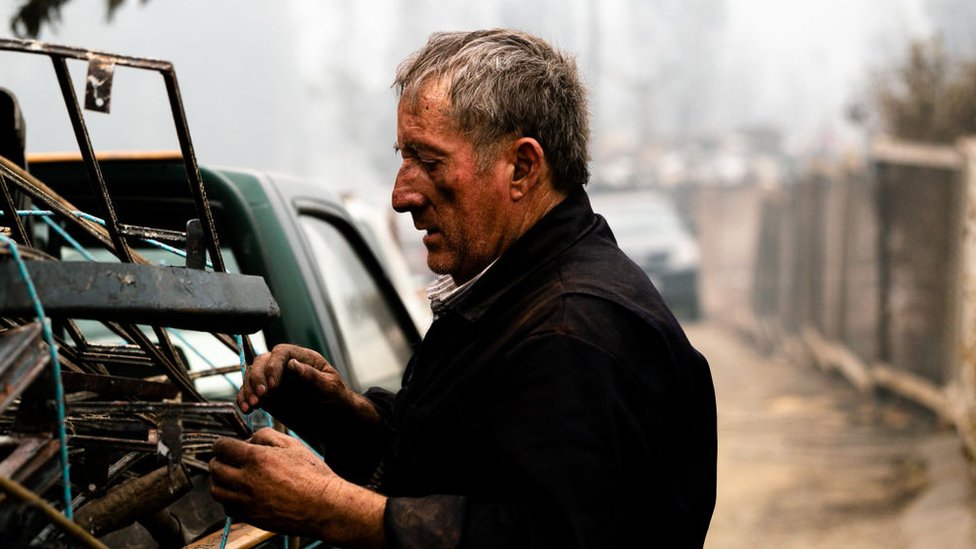 Un hombre con el rostro manchado de hollín.