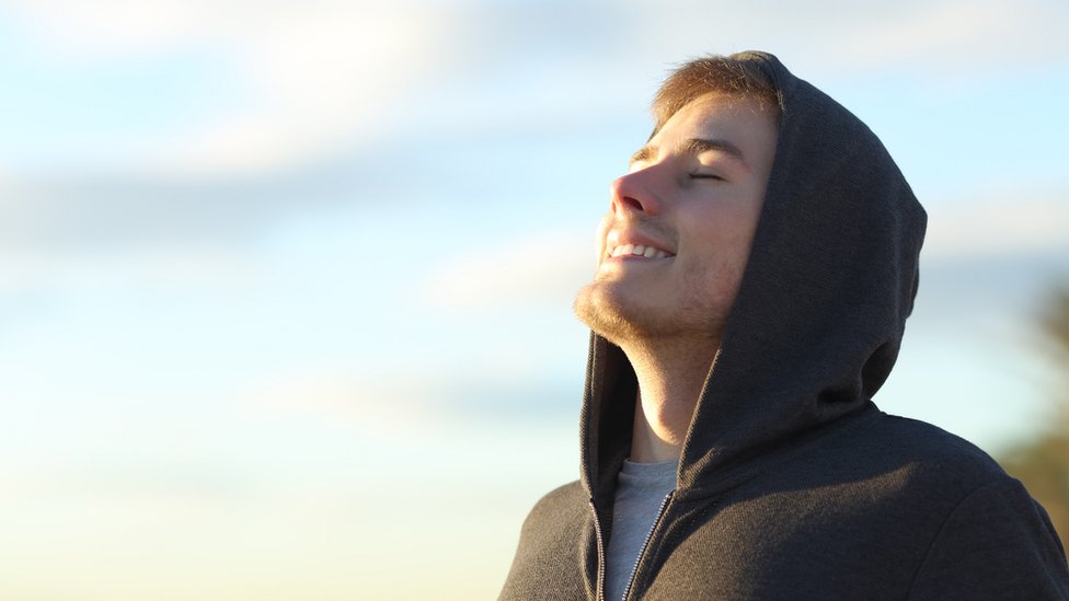 Hombre joven tomando una respiración profunda.