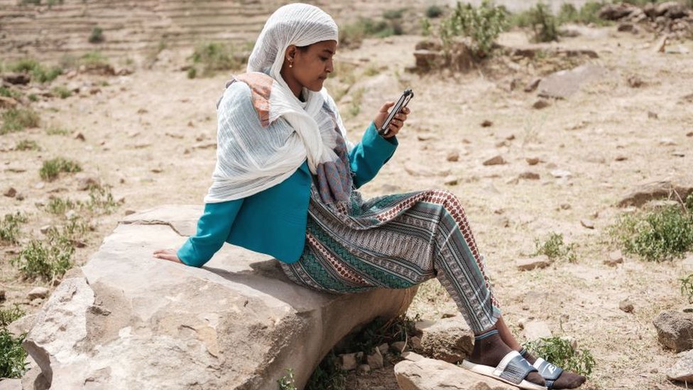 Una mujer mirando un teléfono móvil en la región de Tigray, Etiopía.