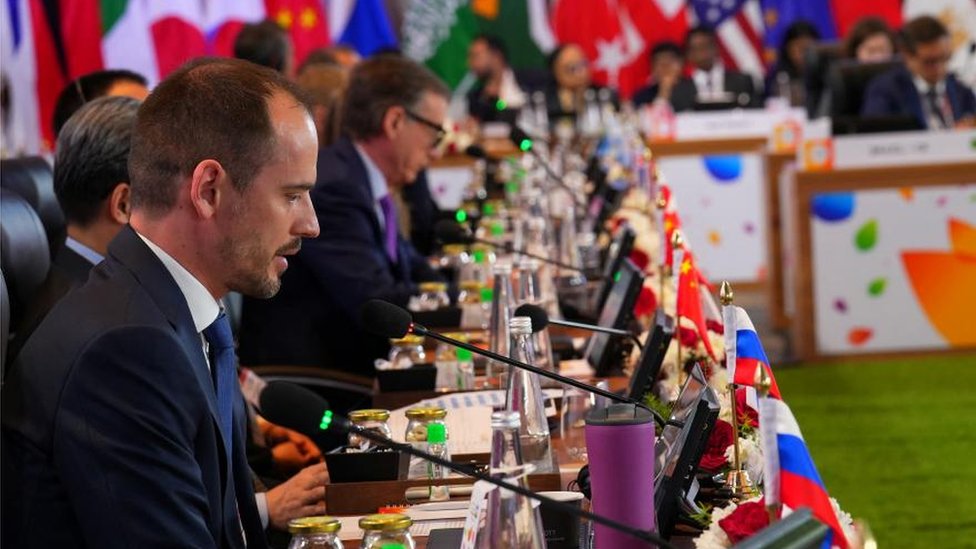 Un delegado ruso se sienta en una mesa larga de ministros de finanzas y gobernadores de bancos centrales del G20 en una reunión en Bangalore, India.