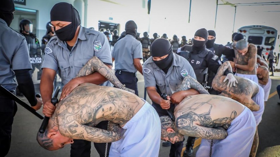 Prison agents guard gang members as they are processed at their arrival after 2000 gang members were transferred to the Terrorism Confinement Center,
