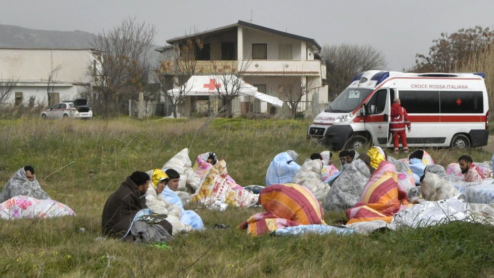 Sobrevivientes del naufragio en Calabria, envueltos en mantas.