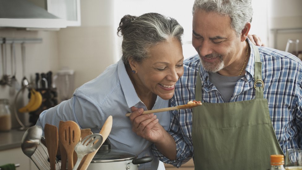 Una pareja cocinando.