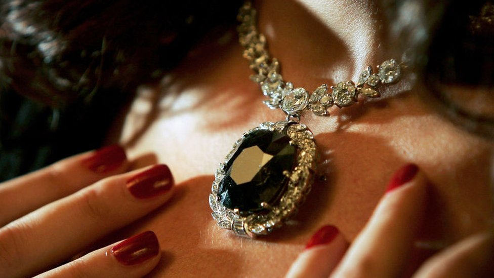 Una mujer luciendo el diamante negro.