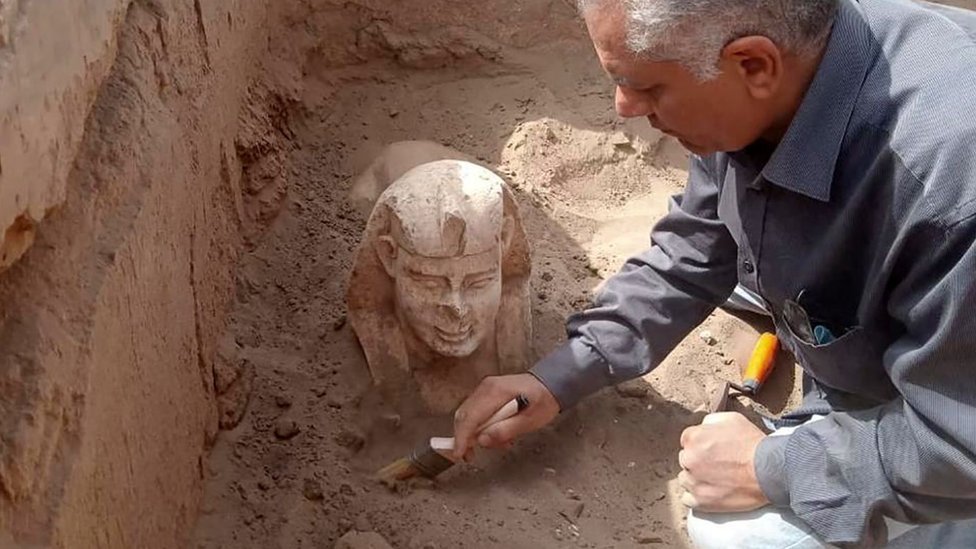 Un arqueólogo desentierra la estatua de una esfinge durante una excavación en Egipto