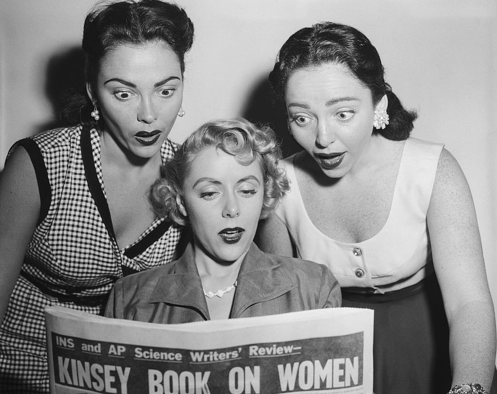Dos de las cantantes del grupo Barry Sisters y la actriz Barbara Lawrence leyendo sobre el estudio de Kinsey.