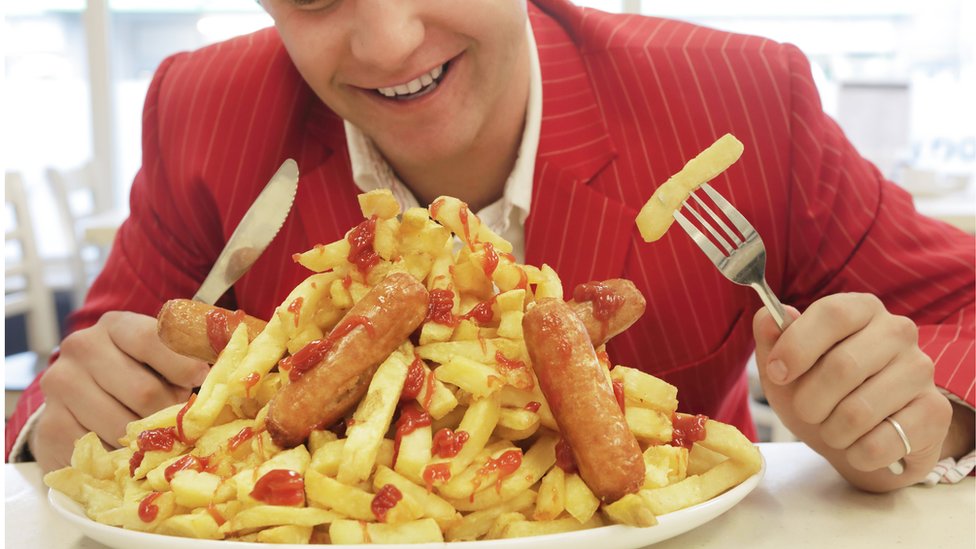 Hombre comiendo un gran plato de comida.