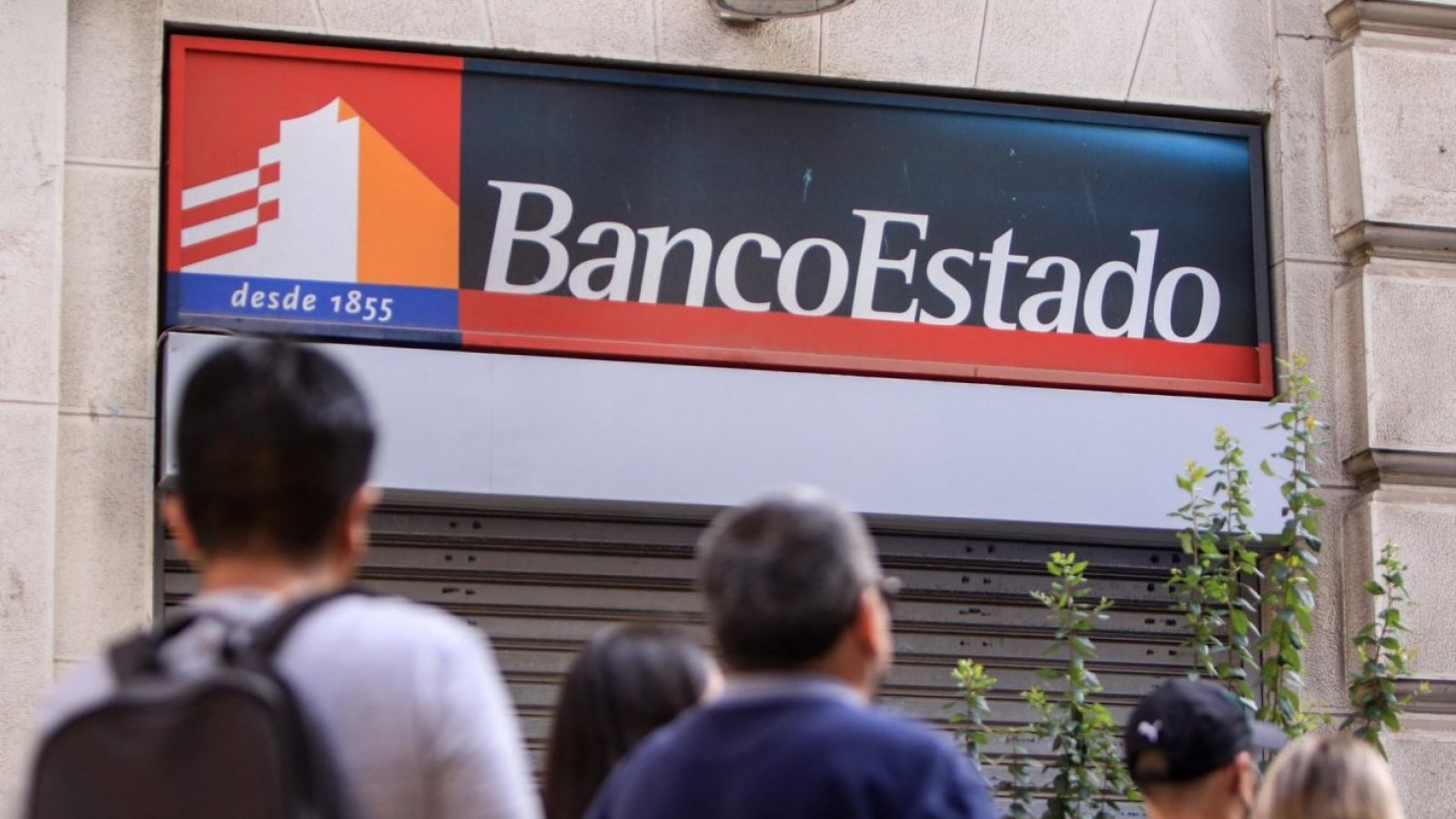 Personas haciendo fila para ingresar a una sucursal de BancoEstado