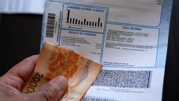 Persona con cuenta de luz y dinero en la mano