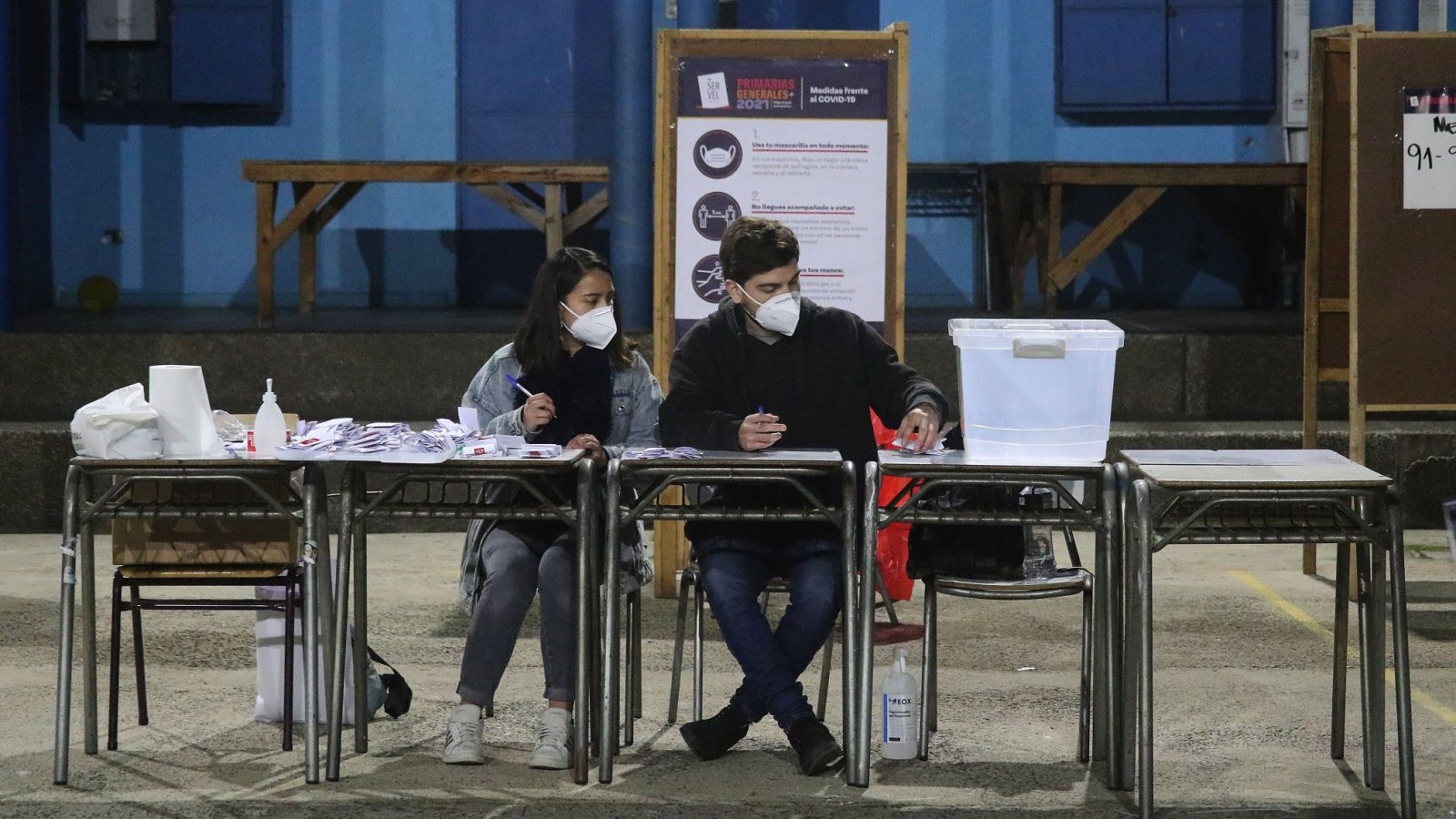 Vocales de mesa sentados en un local de votación.