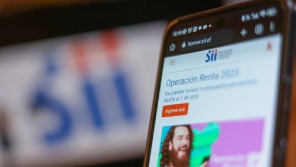 Celular y pantalla con pestaña abierta de la web del Servicio de Impuestos Internos (SII)