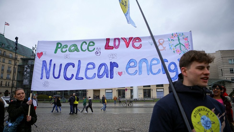 Un manifestante con una pancarta que dice: Paz, amor y energía nuclear