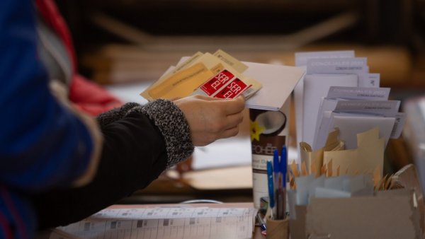 Vocal de mesa contando votos encima de mesa.
