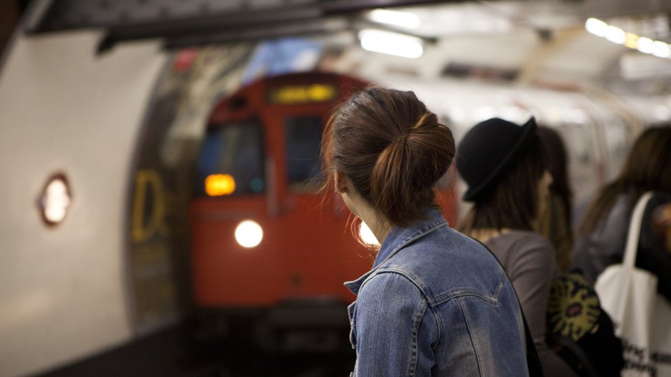 Personas esperando a que llegue un tren del Metro de Londres.