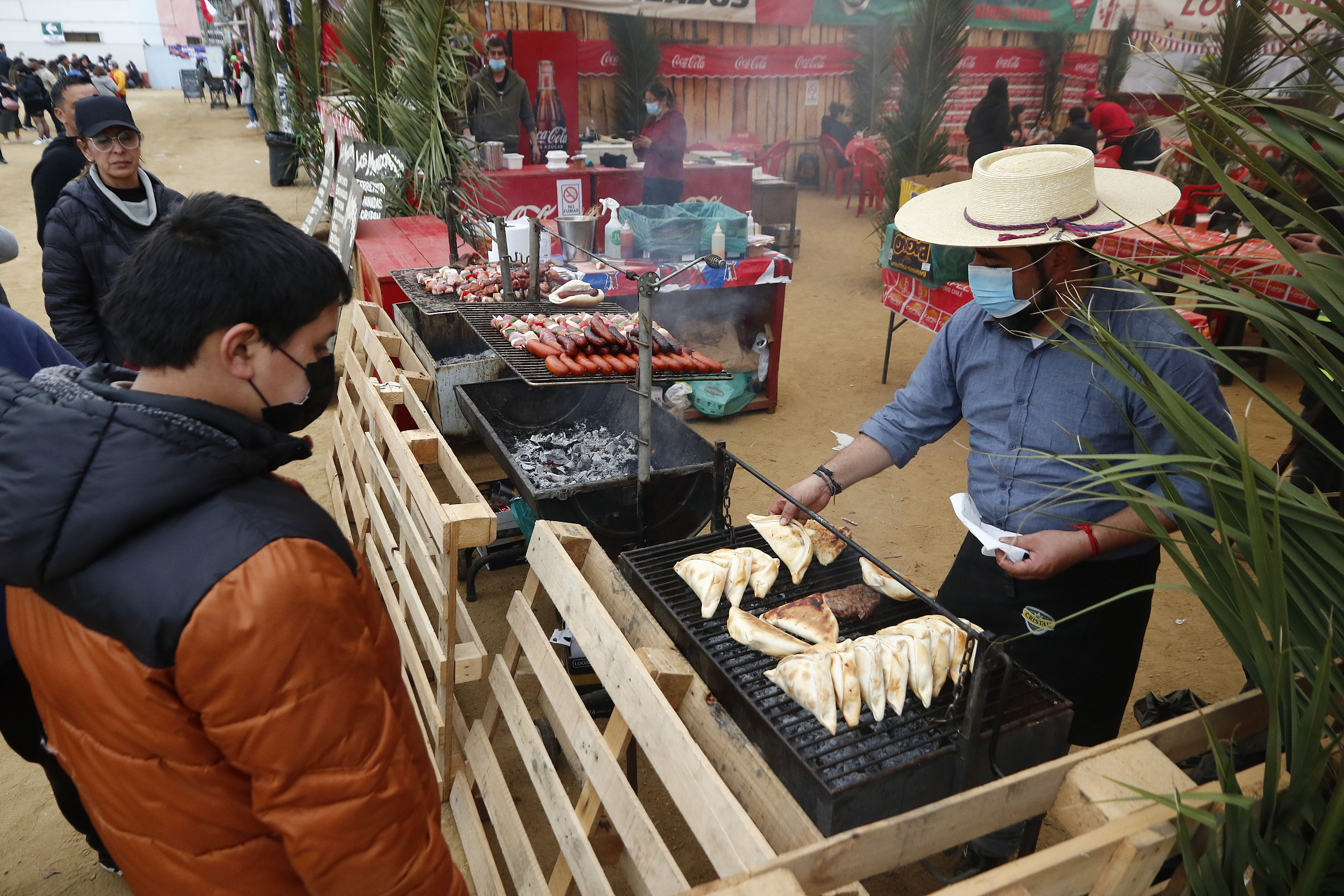 Personas comprando empanadas en fonda de Fiestas Patrias