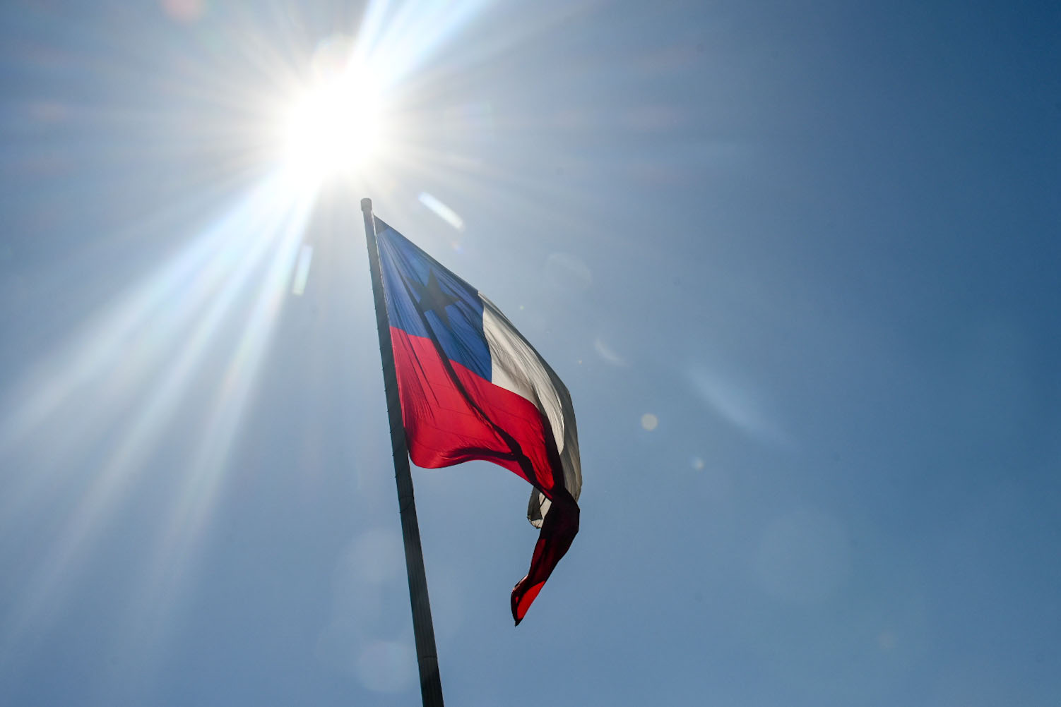 Bandera de Chile con un sol brillante de fondo.