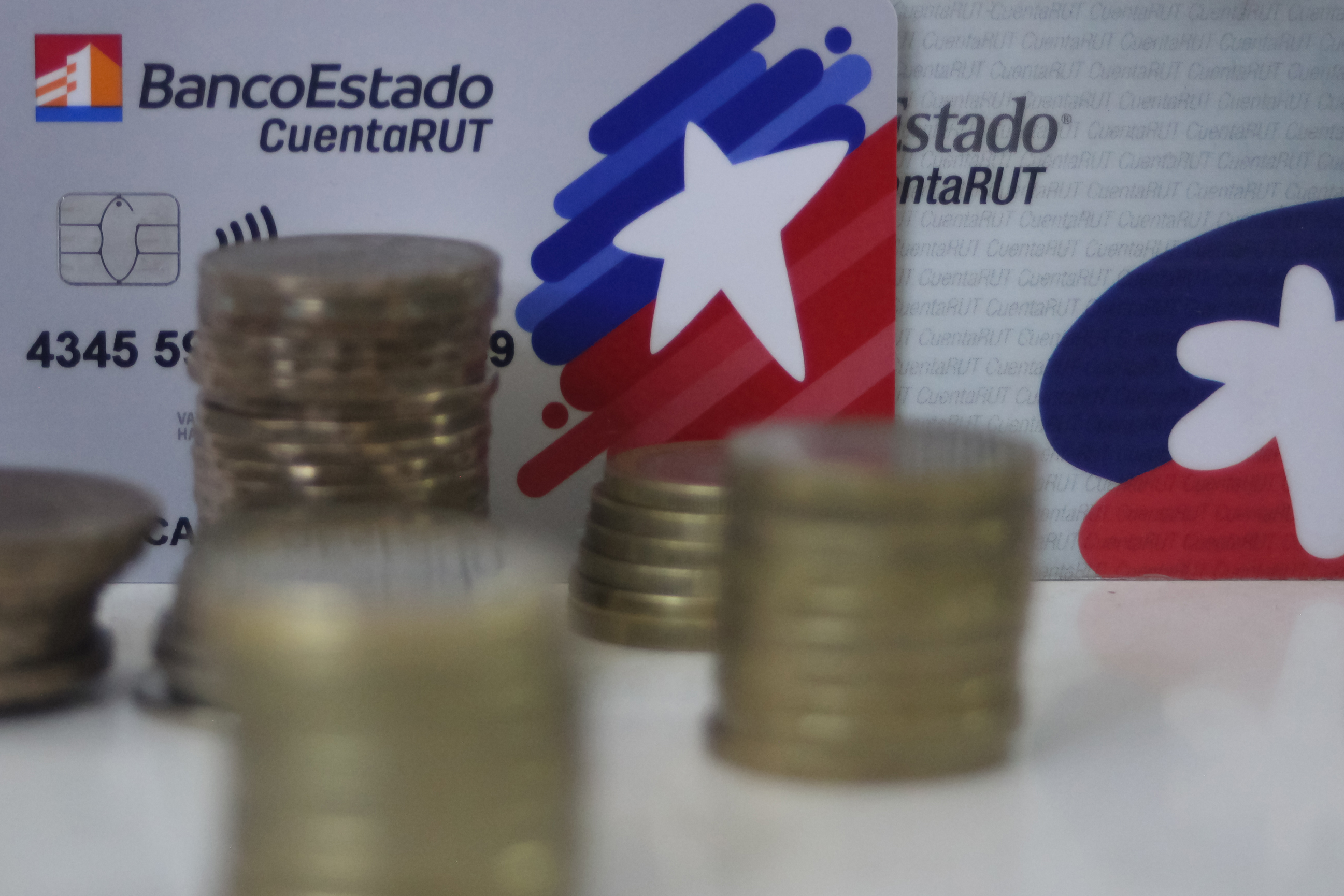 Moderas de pesos chilenos y en el fondo tarjetas de CuentaRUT 
