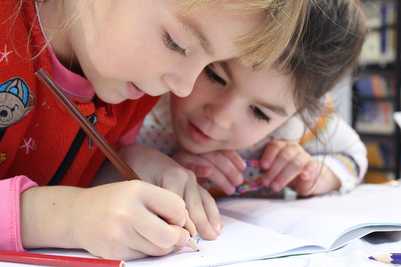 Dos niños pintando un dibujo