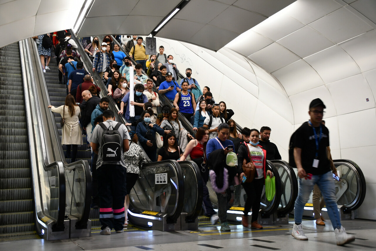 Personas bajando de una escalera del Metro de Santiago.