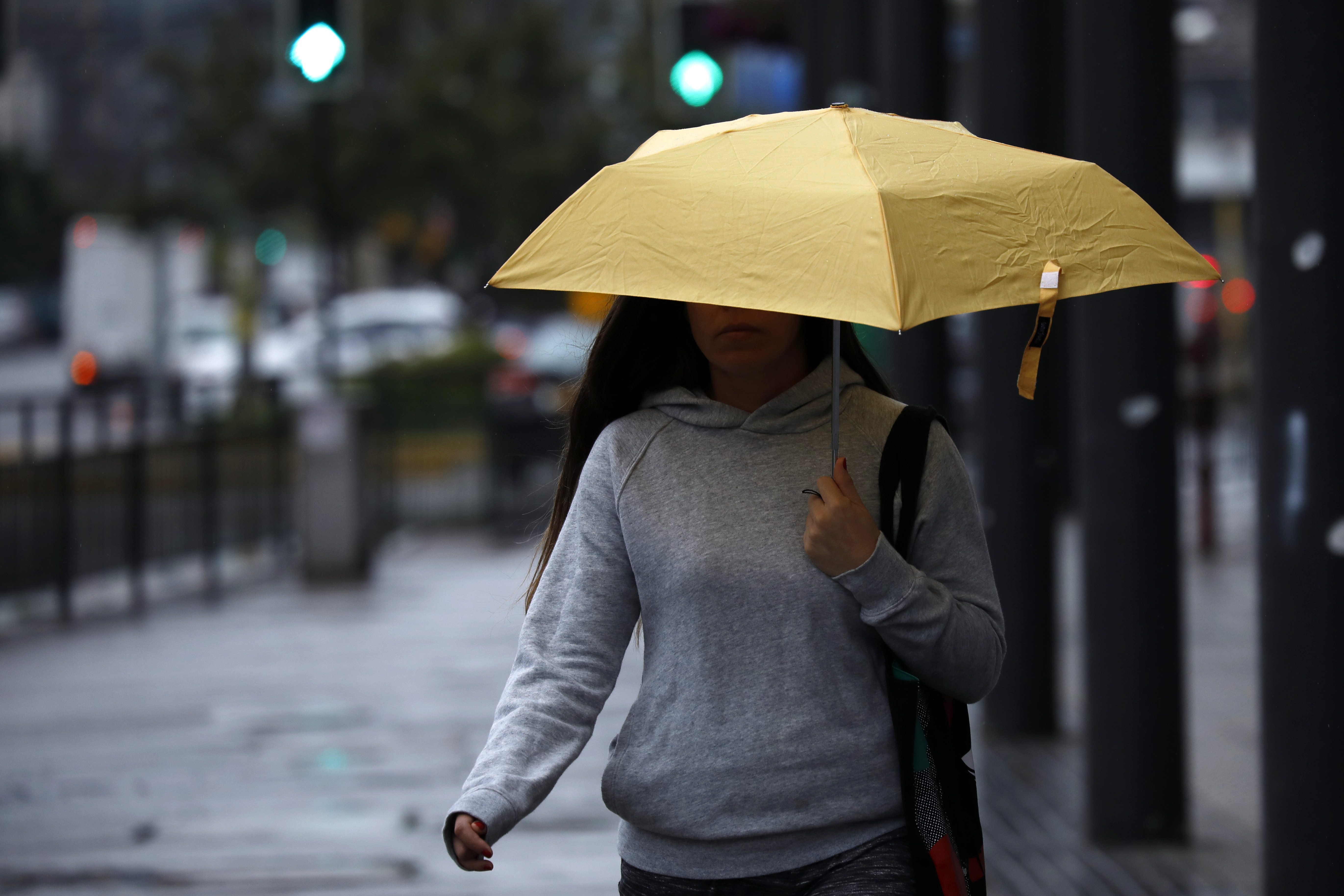 Persona con paraguas caminando por la calle