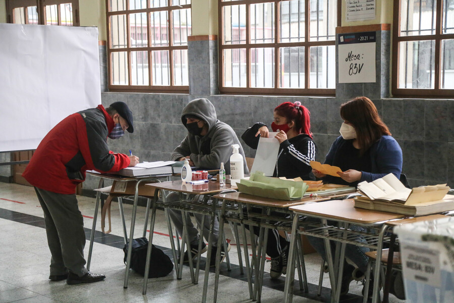 Persona sufragando en una mesa de votación.