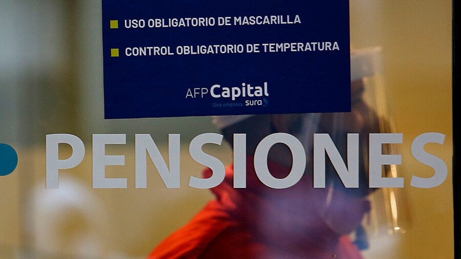 Persona detrás de mampara de sucursal AFP