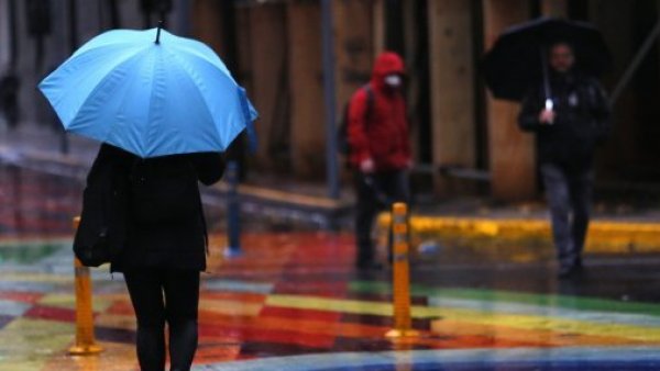 Persona con paraguas caminando bajo la lluvia en Santaigo Centro