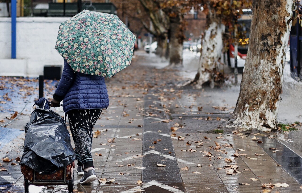 Persona caminando bajo la lluvia en la RM.