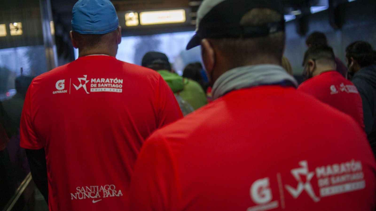 Personas de espalda con la polera de la Maratón de Santiago.