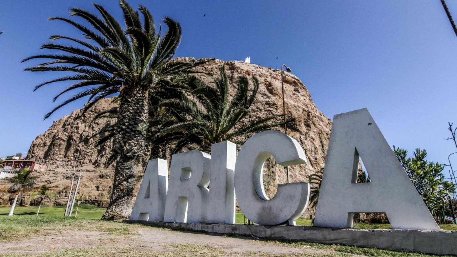 Letrero con la palabra Arica y de fondo el morro de Arica.