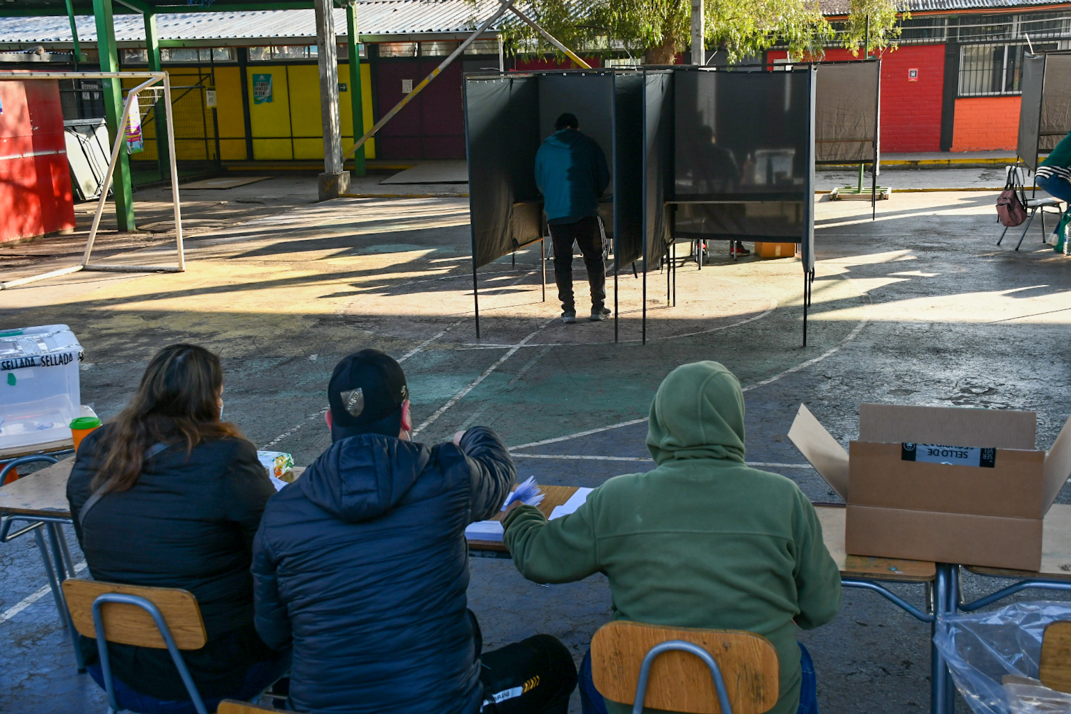 Vocales de mesa esperan a votante que está en la urna.