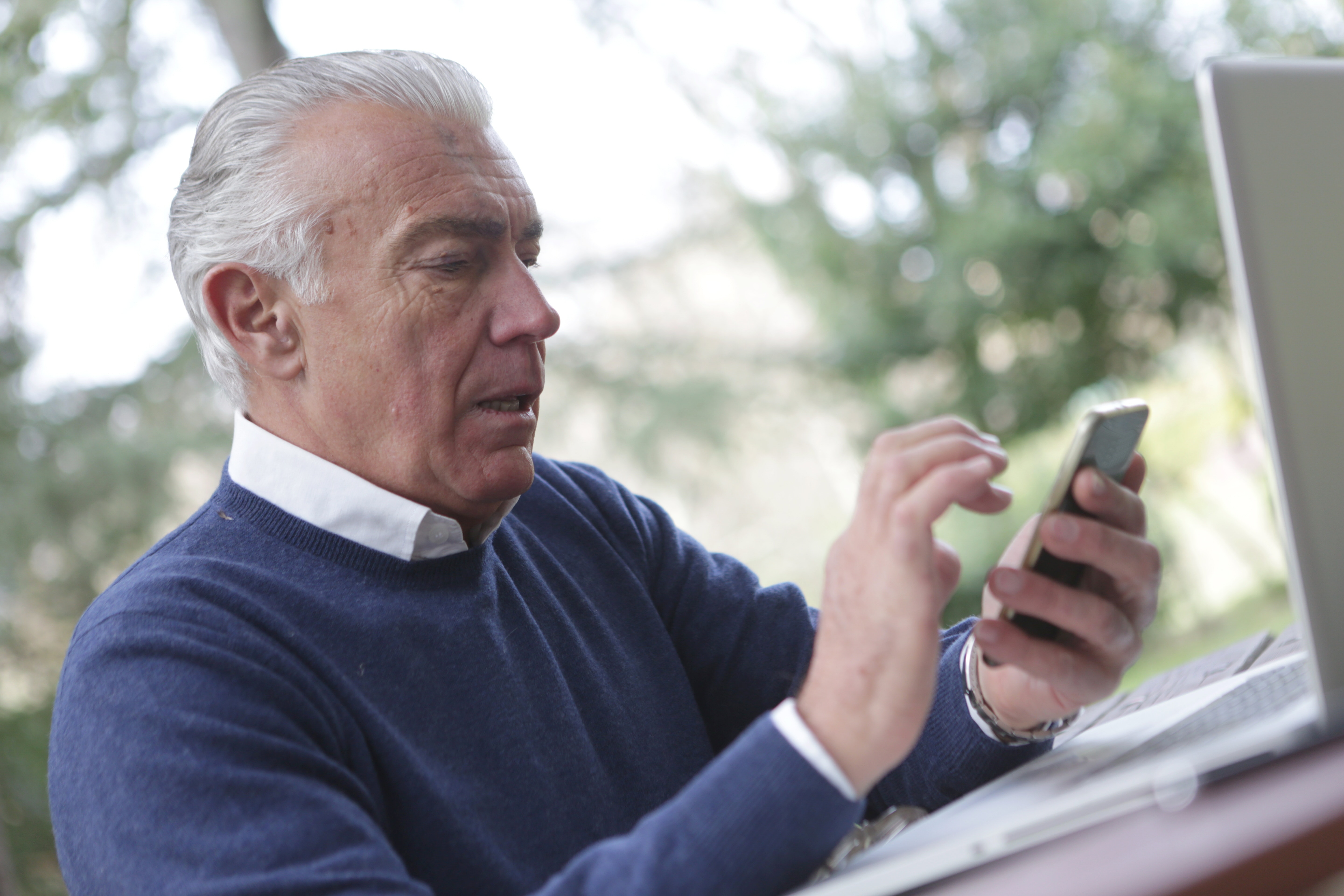 Hombre sentado revisando su celular