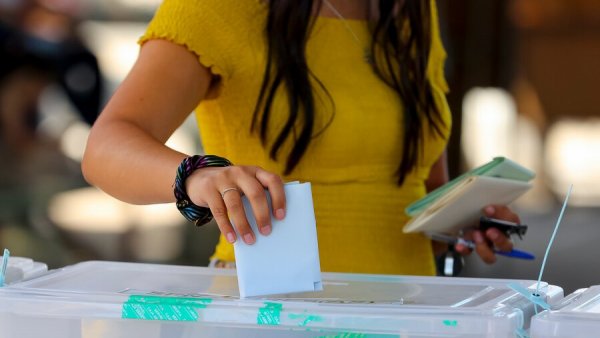 Mujer ingresando su voto en una urna.