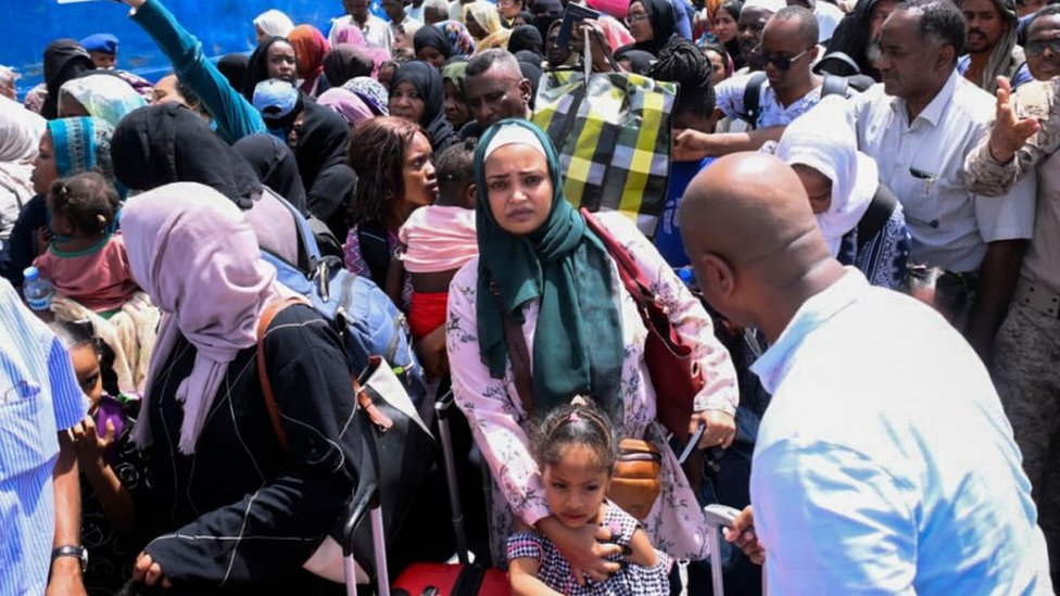 Personas que huyen de un Sudán devastado por la guerra hacen fila para abordar un barco en Puerto Sudán el 28 de abril de 2023.