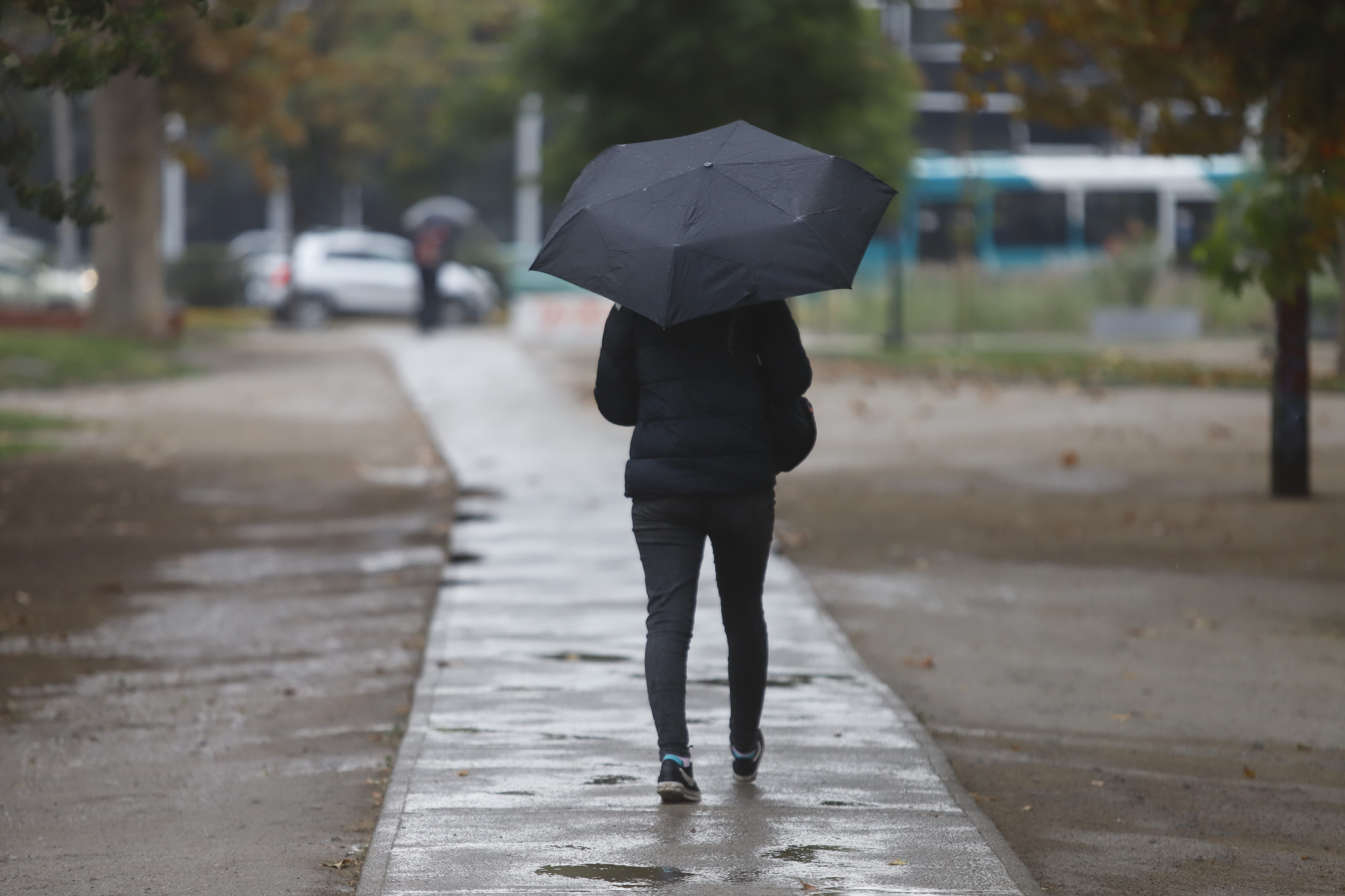 Persona bajo la lluvia con paraguas en Santiago.