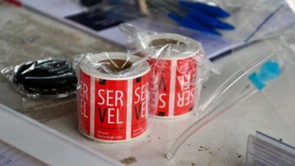 Pegatinas del Servel sobre una mesa de votación.