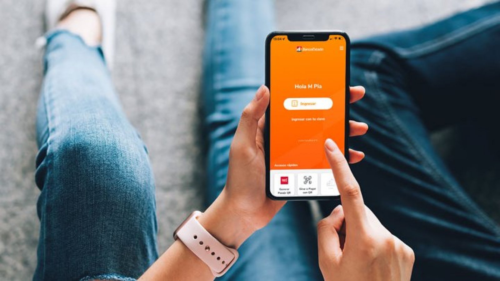 Persona sosteniendo su celular mientras revisa app de BancoEstado