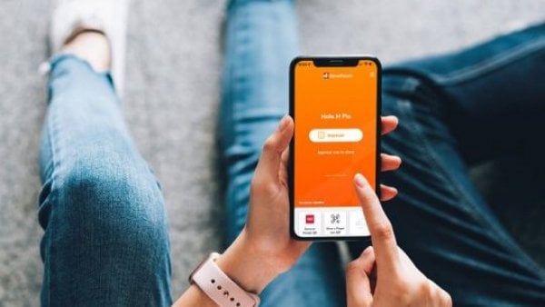 Persona sosteniendo su celular mientras revisa app de BancoEstado