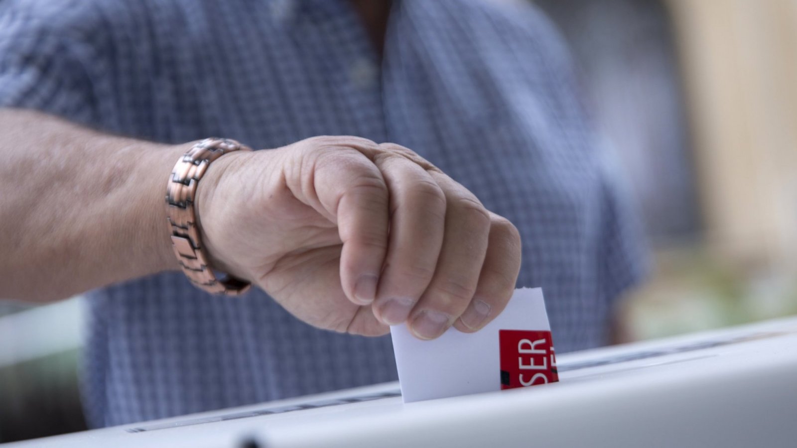 Persona ingresando su voto en una urna electoral.