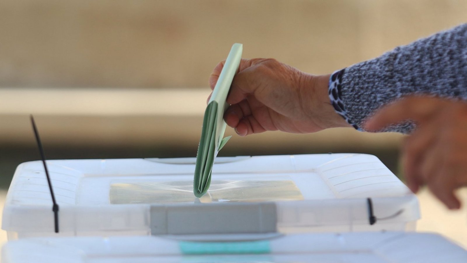 Persona votando en una urna.