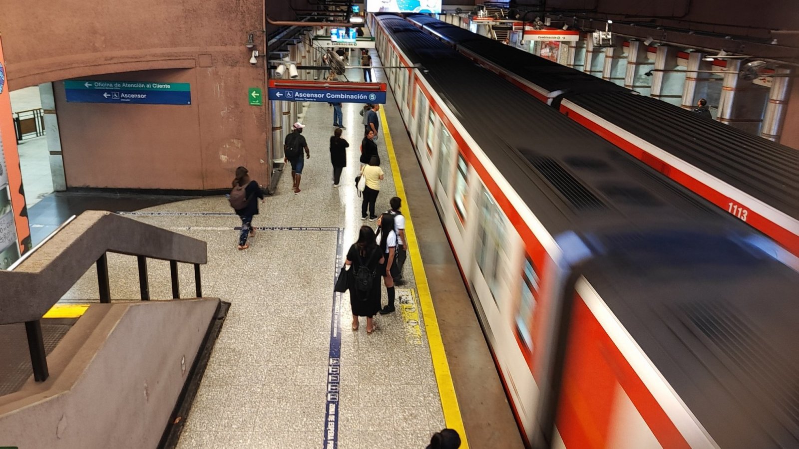 Metro de Santiago llegando al andén, con gente esperando.