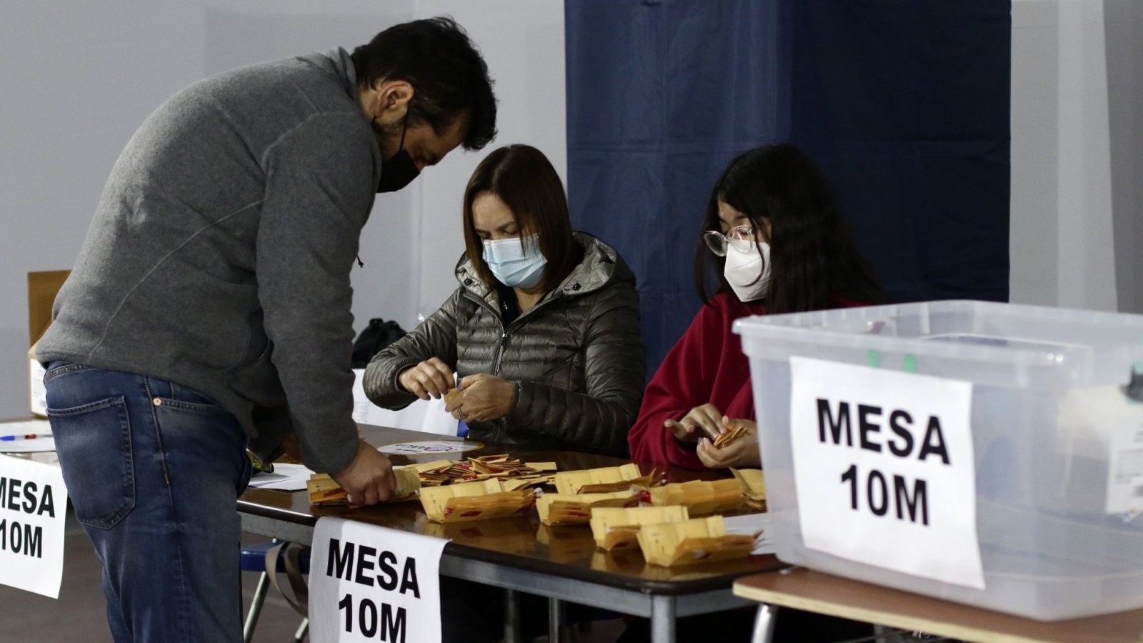 Persona en una mesa de votación retirando su voto