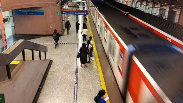 Metro de Santiago llegando al andén, con gente esperando.