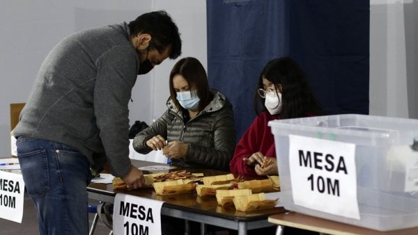 Persona en una mesa de votación retirando su voto