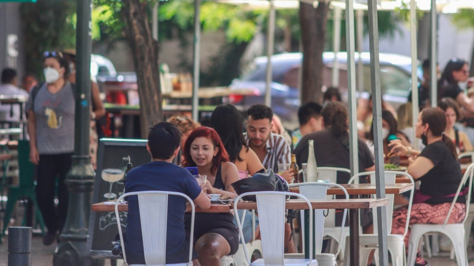 Personas comiendo en terraza de restaurante