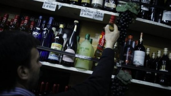 Hombre mostrando las botella de alcohol de una botillería