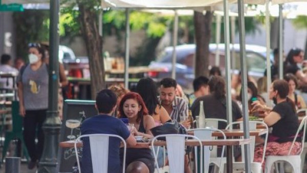 Personas comiendo en terraza de restaurante