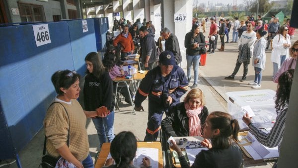 Personas haciendo fila en una mesa de votación para las elecciones